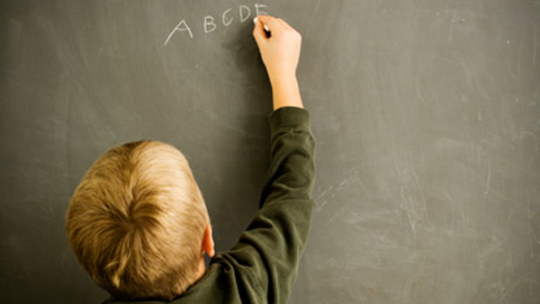 child writing on blackboard