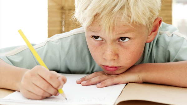 child writing and looking up